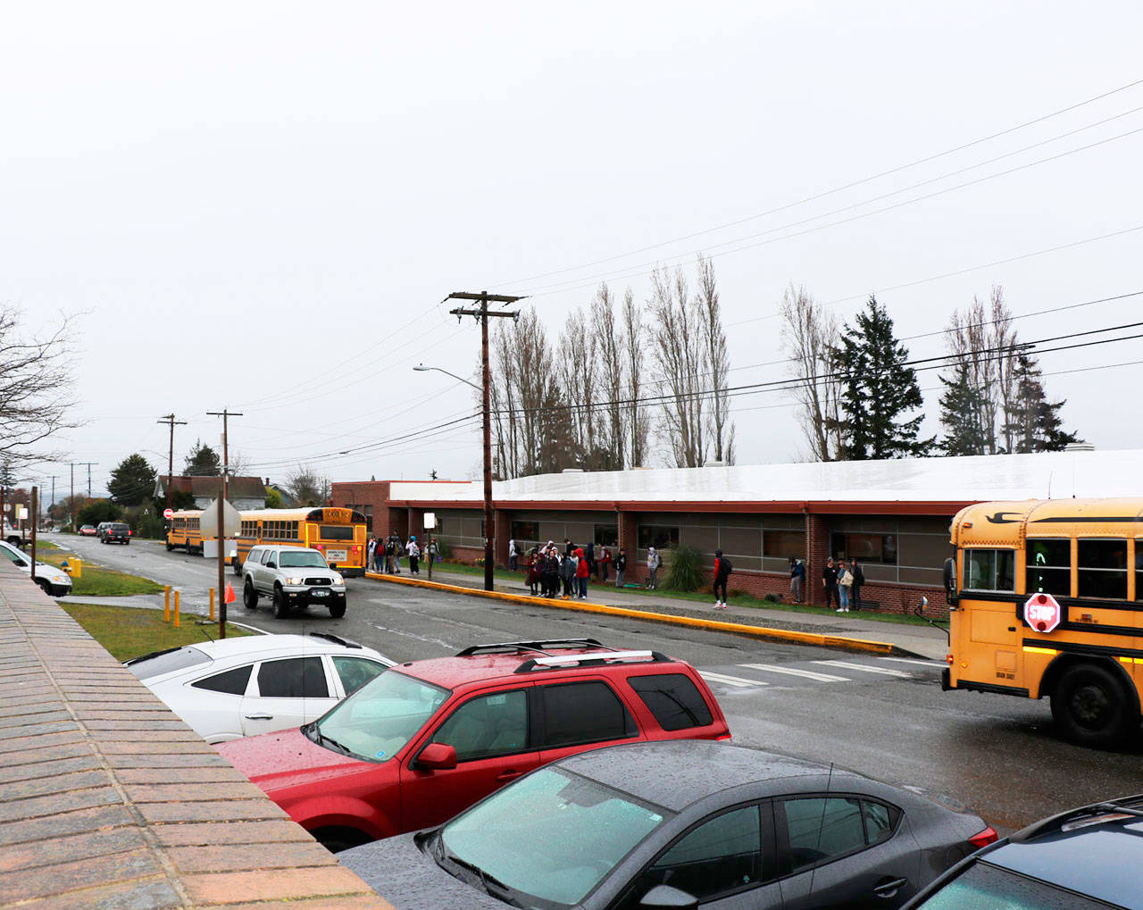 Port Townsend High School students wait to board their buses home on Friday afternoon. The students will be on a six-week break beginning Tuesday following a decision made by Gov. Jay Inslee, in an effort to tamper down the spread of COVID 19. (Ken Park/Peninsula Daily News)