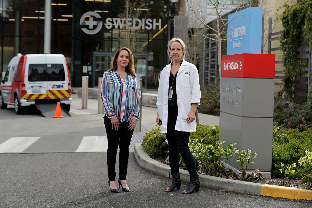 In this Tuesday, March 24, 2020, photo, Melissa Short, left, system executive director for women’s health at Swedish Medical Center, and Dr. Tanya Sorensen, a practicing maternal fetal medicine physician at Swedish, and executive director for women’s services, pose in front of the center in Edmonds, north of Seattle. Several dozen expectant moms who had planned to give birth at the birth unit of the center will now have to go elsewhere because the facility is being repurposed to treat victims of the new coronavirus. (Ted S. Warren/The Associated Press)