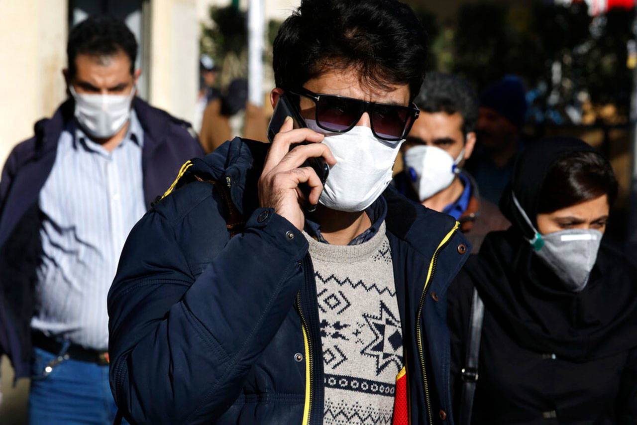 In this Monday, March 2, 2020, file photo, a man wearing a face mask, to help protect against the new coronavirus, speaks on his cellphone in downtown Tehran, Iran. Local media reported Thursday, March 26, 2020, that nearly 300 people have been killed and more than 1,000 sickened by ingesting toxic methanol across the Islamic Republic out of the false belief it kills the new coronavirus. That’s as messages forwarded through social media on people surviving the virus by drinking whiskey and using alcohol-based hand sanitizer somehow saw people seek out bootleg liquor in Iran. (Vahid Salemi/The ASsociated Press file)