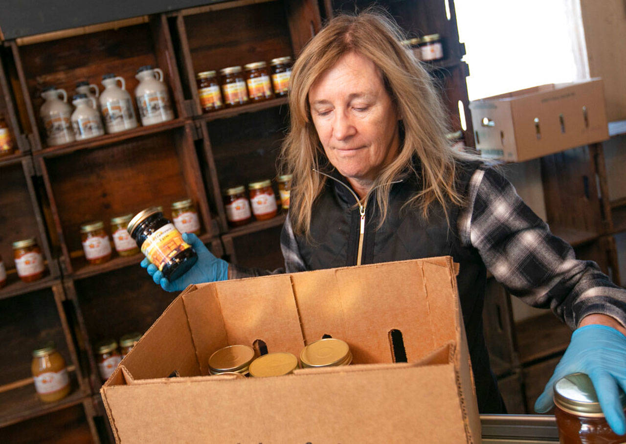 Linda DeFrancesco stocks shelves with her farm’s own salsa, spreads, veggies and salsa at DeFrancesco Farm Stand in Northford, Conn., on Thursday, March 26, 2020. Businesses across the state are worried about the impact of the coronavirus, even the ones considered “essential,” like farmers markets and garden centers. (Dave Zajac/Record-Journal via AP)