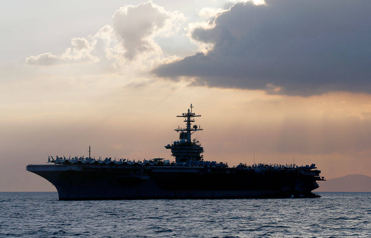In this April 13, 2018, file photo, the USS Theodore Roosevelt aircraft carrier is anchored off Manila Bay west of Manila, Philippines. The captain of the U.S. Navy aircraft carrier facing a growing outbreak of the coronavirus is asking for permission to isolate the bulk of his roughly 5,000 crew members on shore, which would take the warship out of duty in an effort to save lives. The ship is docked in Guam (Bullit Marquez/Associated Press file)