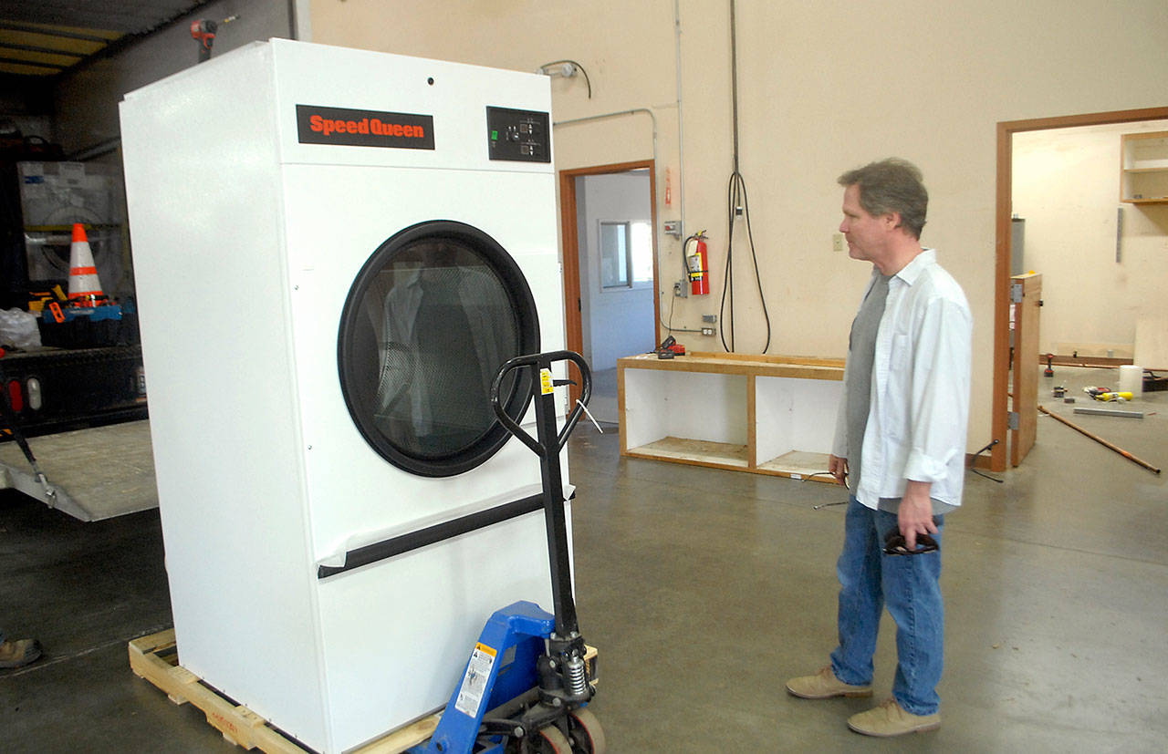 Kevin Lopiccolo, deputy director of Clallam County Health and Human Services, looks over a newly-delivered commercial clothes dryer to be installed Thursday, April 9, 2020, in the Port of Port Angeles’ 1010 Building near William R. Fairchild International Airport prior to the building’s temporary conversion to an isolation shelter of homeless individuals. (Keith Thorpe/Peninsula Daily News)