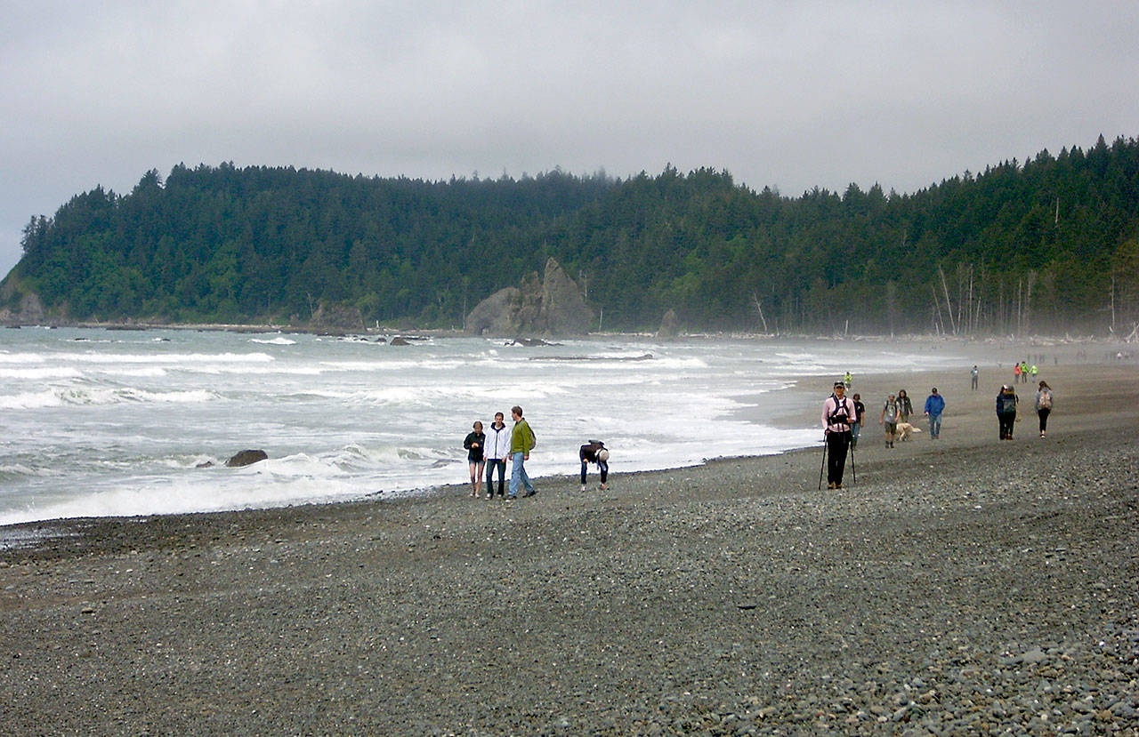 Visitors walk along the shoreline near Hole in the Wall on Rialto Beach in Olympic National Park in May 2015. Olympic National Park has closed all National Park Service-managed beaches and coastal areas on the Olympic Peninsula to park visitors to slow the spread of COVID-19. (Keith Thorpe/Peninsula Daily News file)