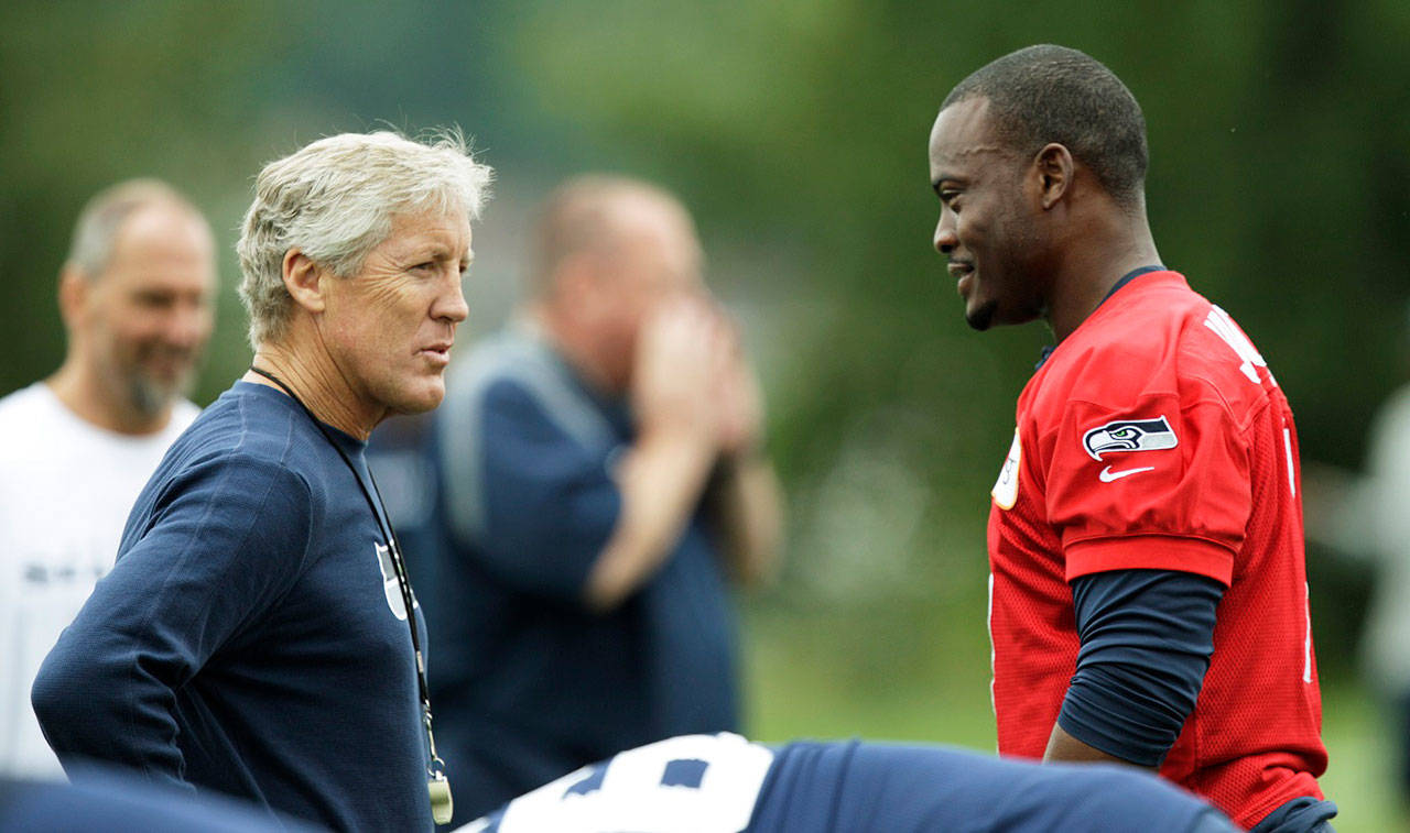 Seattle Seahawks coach Pete Carroll, left, chats with quarterback Tavaris Jackson, right, Saturday, July 28, 2012, on the first day of Seattle Seahawks NFL football training camp. (Ted S. Warren/The Associated Press file)