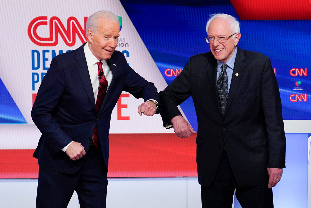 Former Vice President Joe Biden, left, and Sen. Bernie Sanders, I-Vt., right, greet each other before they participate in a Democratic presidential primary debate at CNN Studios in Washington on Sunday, March 15, 2020. (Evan Vucci/The Associated Press file)