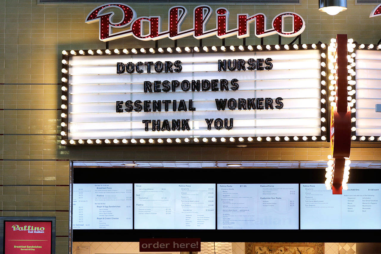 A still-open restaurant gives a thanks to medical personnel and essential workers from an overhead sign at Seattle-Tacoma International Airport Wednesday. About two-third of the restaurants at the airport have closed during the coronavirus outbreak. Flights at the usually busy airport have dropped from up to 1,300 a day to about 400 each day. (Elaine Thompson/The Associated Press)