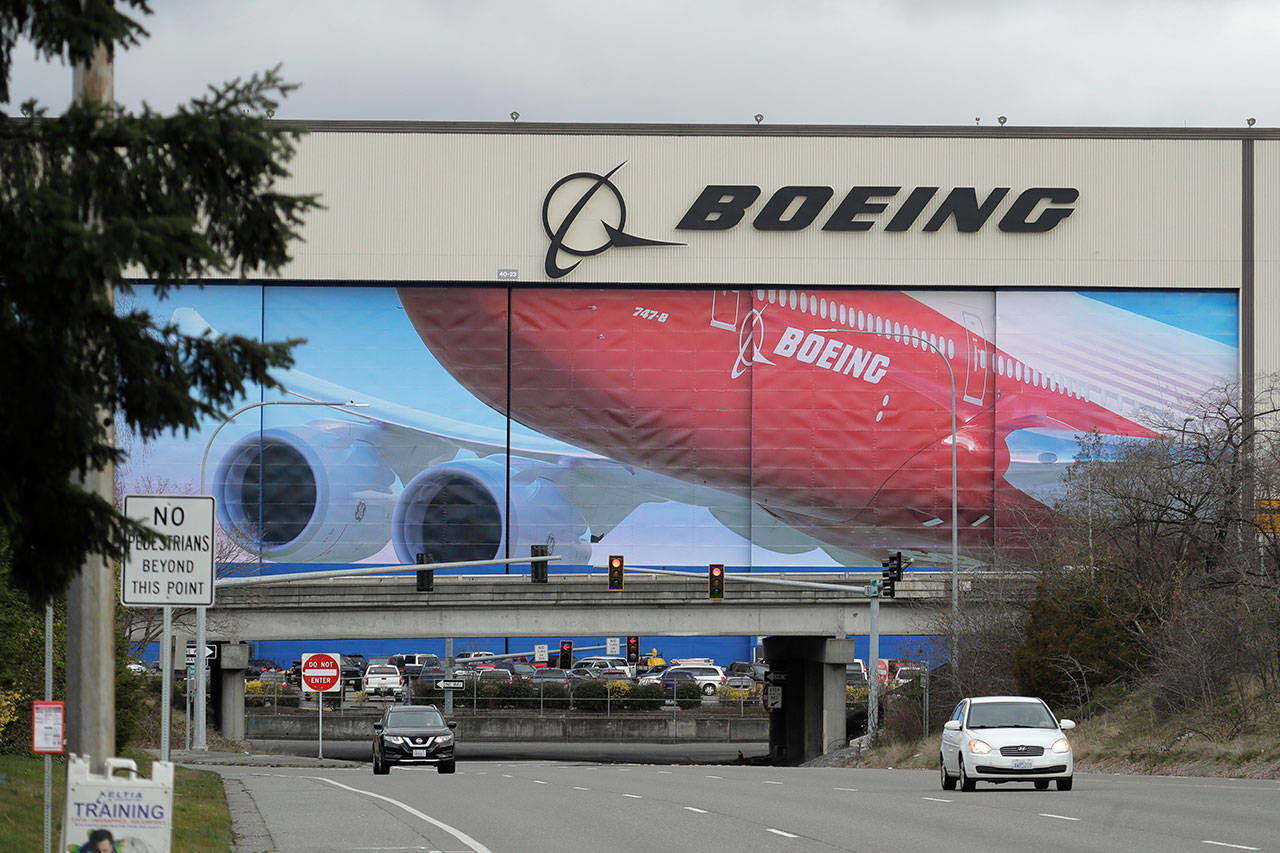 In this March 23, 2020, file photo, cars are driven near Boeing’s manufacturing facility in Everett, Wash., north of Seattle. Boeing says it will resume production of its commercial airplanes in phases at its Seattle area facilities next week after suspending operations in March because of the COVID-19 pandemic. The company says 27,000 of its employees will return to work under new measures put in place to keep people safe and fight the spread of the virus. Employees for the 737, 747, 767 and 777 airplanes will return as early as Monday, April 20, with most returning to work by Tuesday, officials said. (Ted S. Warren/The Associated Press file)
