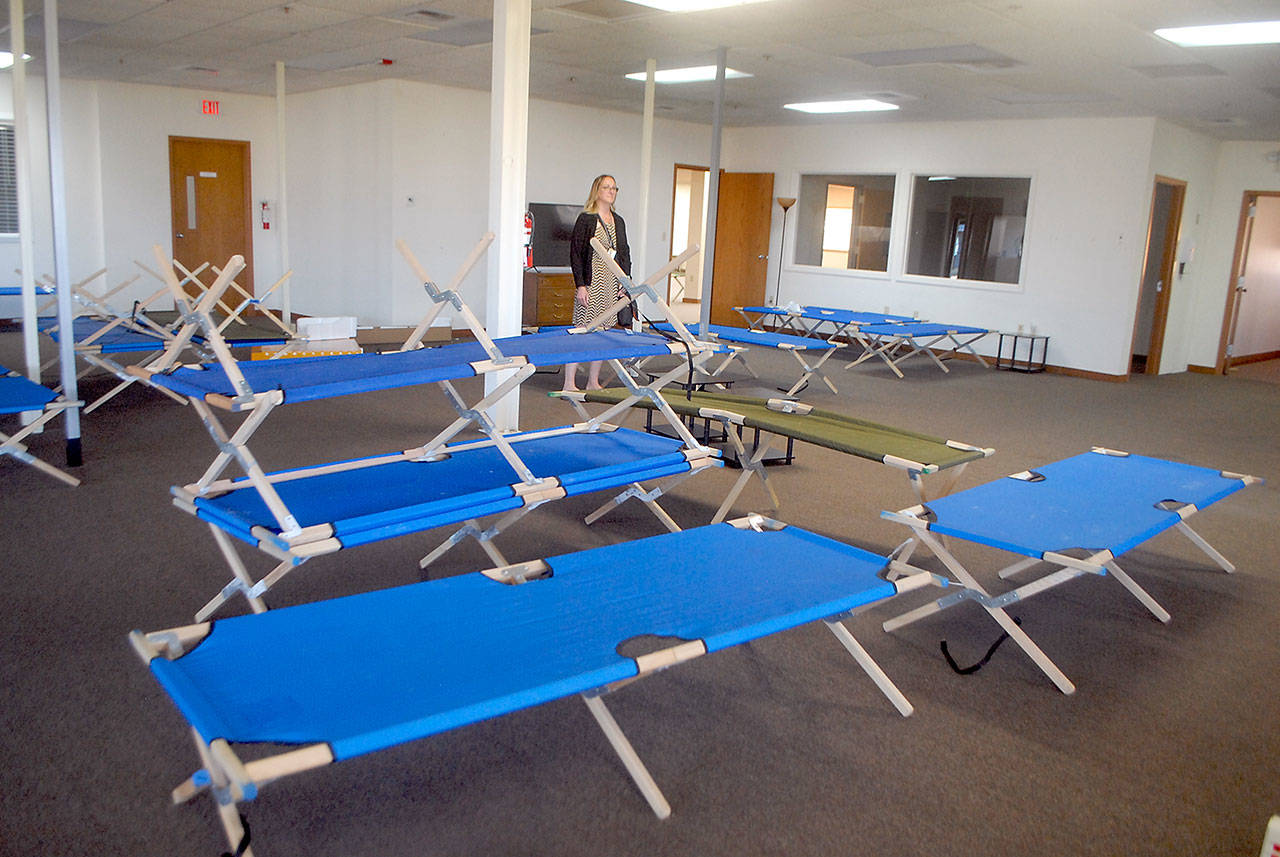 Jess Pankey, an environmental health specialist with Clallam County Heath and Human Services, looks over a room filled with cots Thursday, April 9, 2020, at the Port of Port Angeles’ 1010 Building near William R. Fairchild International Airport as the building is converted to an isolation shelter for homeless individuals who might be infected with the novel coronavirus. (Keith Thorpe/Peninsula Daily News file)