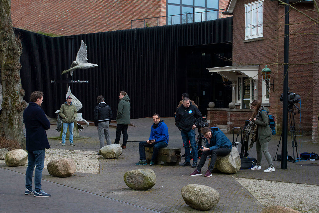In this Monday, March 30, 2020, file photo, journalists wait outside the Singer Museum in Laren, Netherlands, where a Van Gogh painting was stolen. A Dutch crime-busting television show has aired security camera footage showing how an art thief smashed his way through reinforced glass doors at a museum in the early hours of March 30. He later hurried out through the museum gift shop with a Vincent van Gogh painting tucked under his right arm and the sledgehammer in his left hand. (AP Photo/Peter Dejong, File)