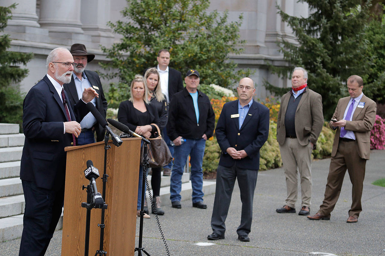 Washington state Sen. Phil Fortunato, R-Auburn, left, speaks outside the Temple of Justice on Thursday, April 23, 2020, at the Capitol in Olympia. Fortunato joined other lawmakers, crime victims, and others in speaking out against the release of prison inmates due to the spread of the coronavirus as Washington state Supreme Court justices heard oral arguments inside on the issue using remote video technology. (Ted S. Warren/Associated Press)