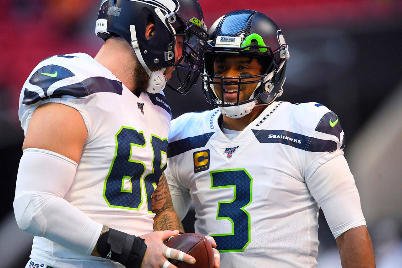 Seattle Seahawks quarterback Russell Wilson (3) speaks with Seattle Seahawks center Justin Britt (68) before the first half of an NFL football game between the Atlanta Falcons and the Seattle Seahawks on Sunday, Oct. 27, 2019, in Atlanta. (John Amis/Associated Press file)