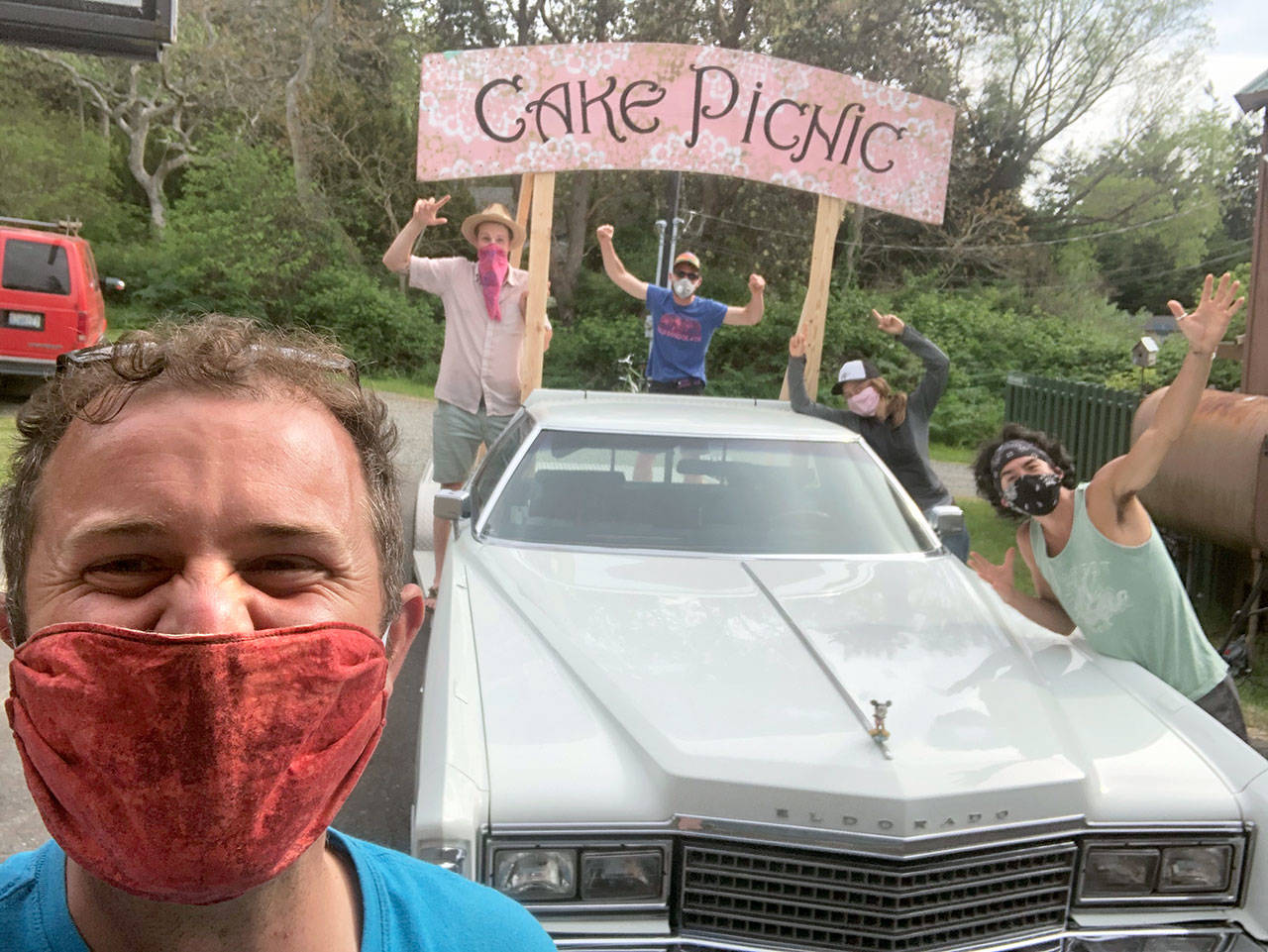 Danny Milholland, longtime organizer of the Cake Picnic, grins behind a face mask in front of the ‘78 Cadillac flatbed that will bring music to Port Townsend residents’ homes Saturday, May 16, 2020. Behind him, from left, are Kellen Lynch, Ben Krabil, Allison Barrett and Tomoki Sage. (Submitted photo)