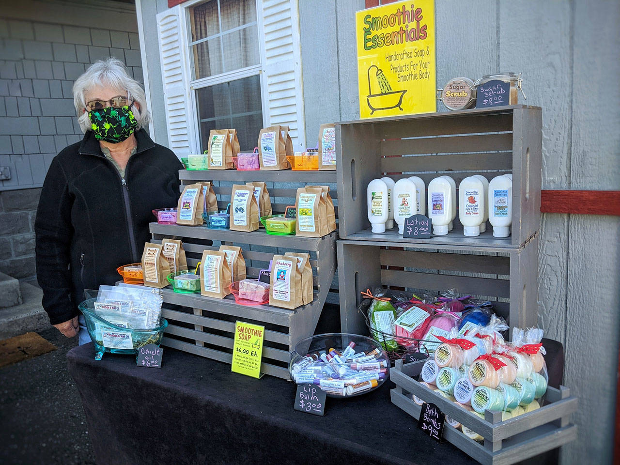 Sheila Gregg, owner of Smoothie Essentials Handmade Soaps, does a test run of her modified booth with essential product for opening day of the Sequim Farmers & Artisans Market, set for Saturday. (Emma Jane Garcia)