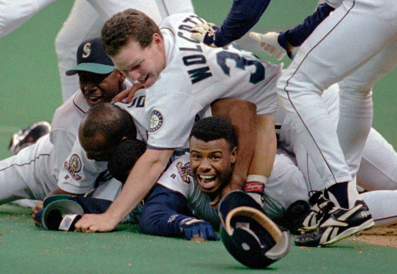 In this Oct. 8, 1995, file photo, Seattle Mariners’ Ken Griffey Jr. smiles from beneath a pile of teammates who mobbed him after he scored the winning run in the bottom of the 11th inning of a baseball game against the New York Yankees, in Seattle. The Seattle Mariners are the only baseball franchise never to advance to the Fall Classic. Baseball has never been played in Seattle beyond Oct. 22. The Mariners have three times been to the American League Championship Series, and all three times were sent home before there could ever be a Game 7. (Elaine Thompson/Associated Press file)