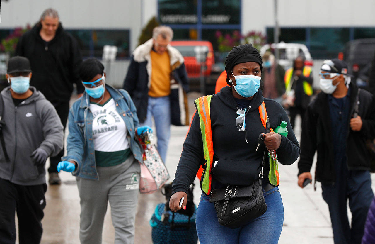United Auto Workers members leave the Fiat Chrysler Automobiles Warren Truck Plant after the first work shift Monday, May 18, 2020, in Warren, Mich. Fiat Chrysler Automobiles NV along with rivals Ford and General Motors Co., restarted the assembly lines on Monday after several week of inactivity due to the corona virus pandemic. (Paul Sancya/Associated Press)