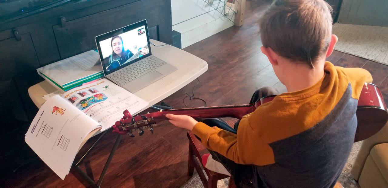 First-grader Leland Munn learns to play the guitar in a Zoom lesson from his teacher Emma Eliason. Eliason teaches Music in the Quilcene School District across all grades.