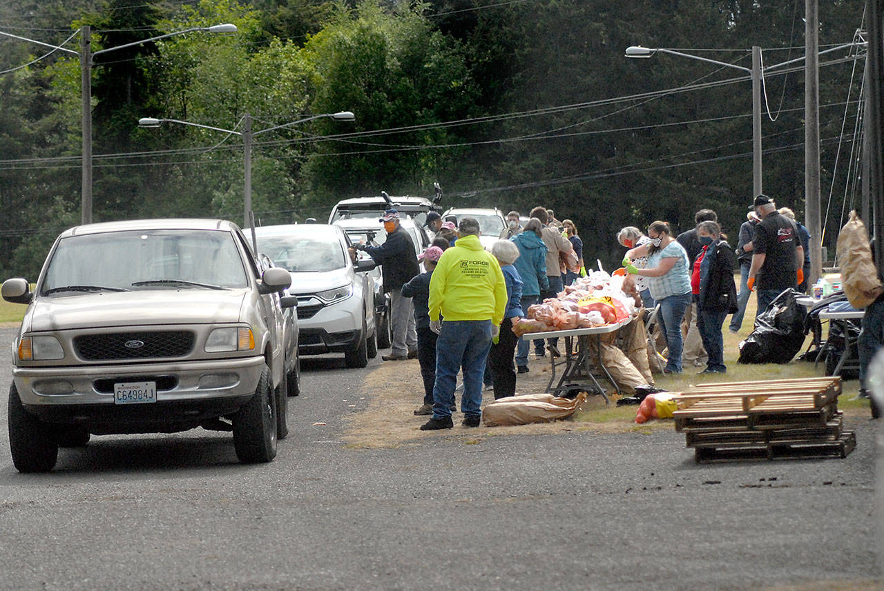Vehicles line up to receive free bags of potatoes and onions during Saturday’s giveaway in the north parking lot of the Clallam County Fairgrounds in Port Angeles. (Keith Thorpe/Peninsula Daily News)