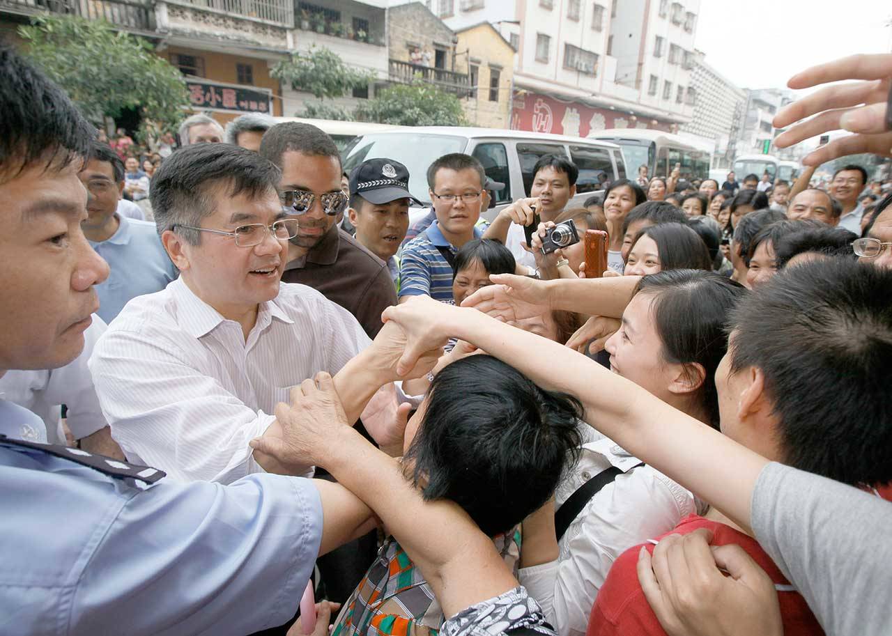 U.S. Ambassador to China Gary Locke, second left, a former Washington state governor, shakes hands with bystanders outside Shuibu kindergarten in Taishan, Guangdong province, southern China on Nov. 4, 2011. (Kin Cheung/Associated Press file)