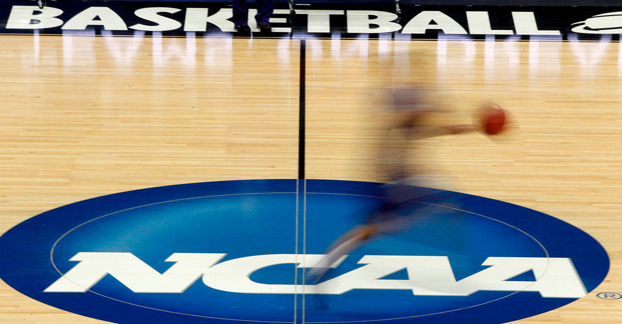 In this March 14, 2012, file photo, a player runs across the NCAA logo during practice in Pittsburgh before an NCAA tournament college basketball game. The number of teams facing postseason bans because of low scores on the NCAA’s Academic Progress Rate has nearly doubled in one year. Fifteen teams could face the most severe sanction next season compared with eight in 2019-20. (Keith Srakocic/Associated Press file)