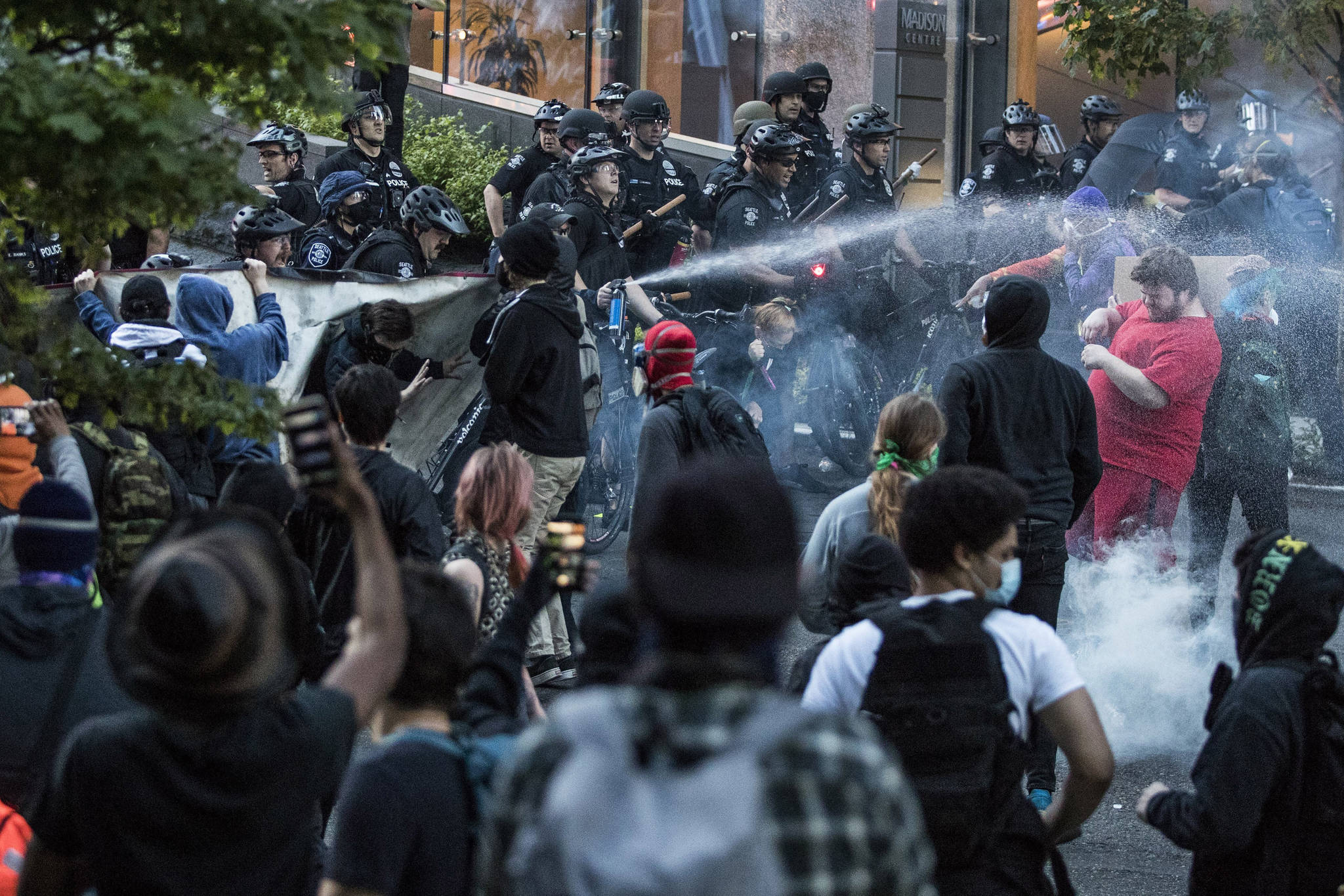 In this May 29, 2020, photo, police push back demonstrators after objects were thrown at them at 5th Avenue and Madison Street during a march in solidarity with Minneapolis and protesting police brutality in Seattle. Protests have been erupting all over the country after George Floyd died earlier this week in police custody in Minneapolis. (Amanda Snyder/The Seattle Times via AP)