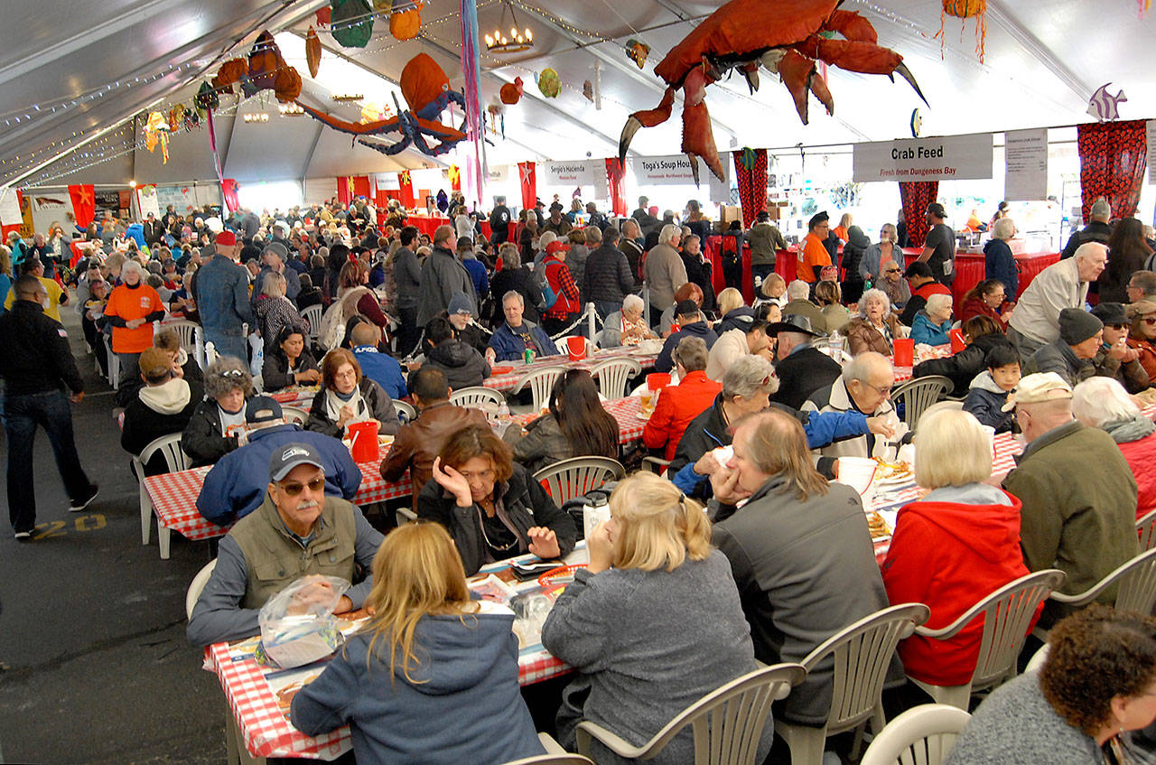 Dungeness Crab & Seafood Festival attendees line up for crab dinners while others dine on a variety of sea food available in the main tent in 2019. (Keith Thorpe/Peninsula Daily News file)