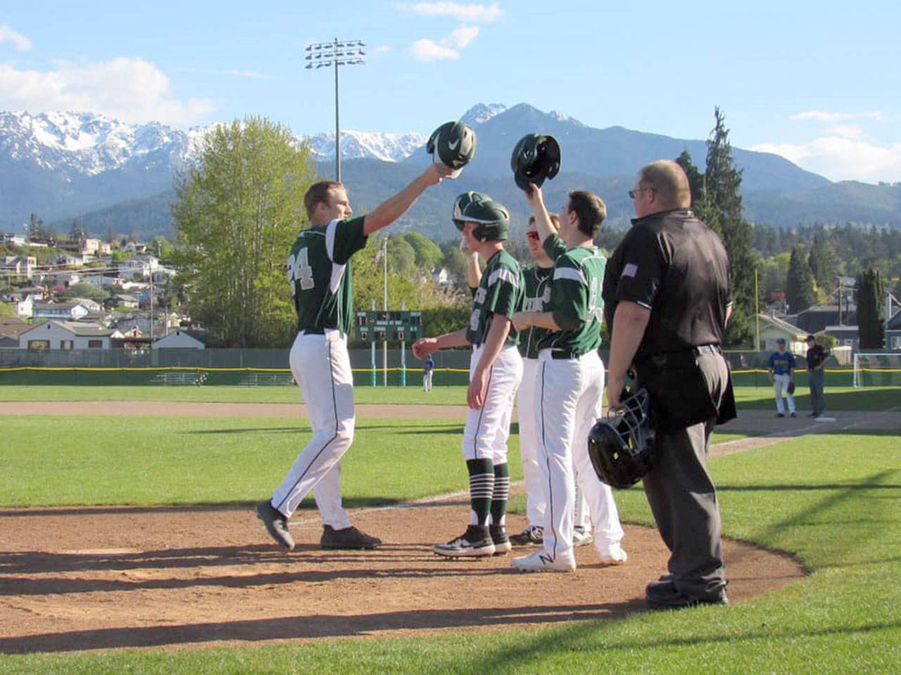 Port Angeles’ Lucas Jarnagin is congratulated at home plate by teammates after hitting the second of two home runs against Bremerton during a 2019 contest at Civic Field.
