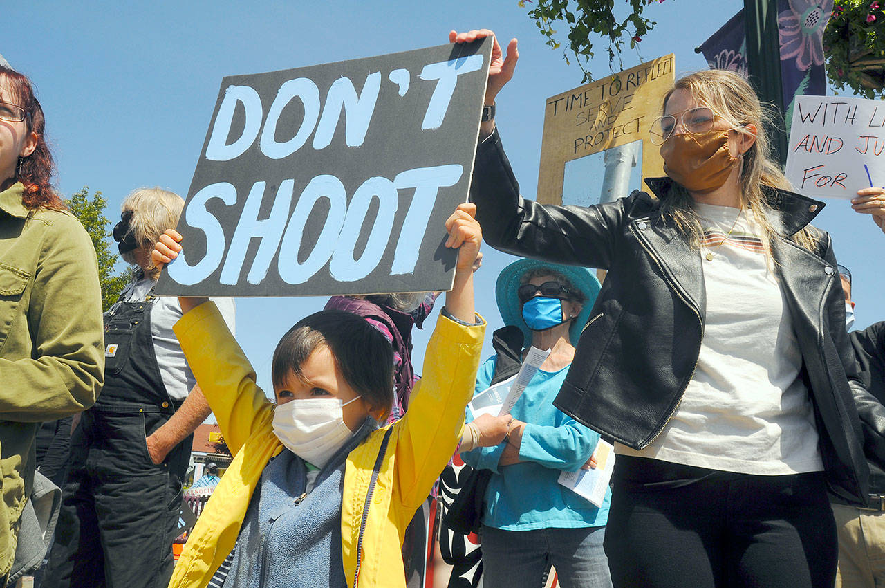 S. Beckett Thomas, 5, holds a “Don’t shoot” sign with mom Courtney Thomas looking on. Courtney organized the protest, saying, “I’m scared for the world, for my son. This [protest] is the least I can do.” (Michael Dashiell/Olympic Peninsula News Group)