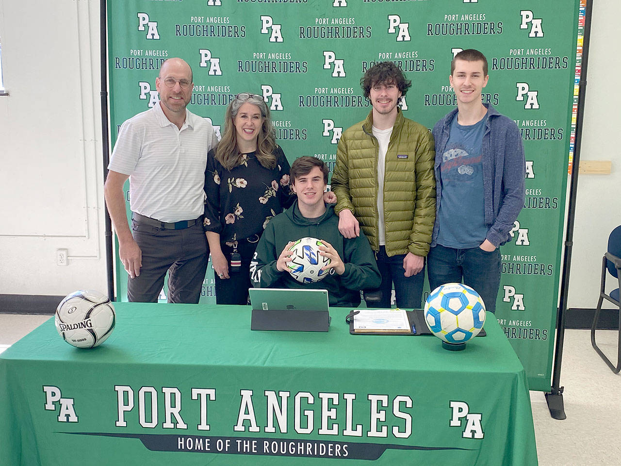 Port Angeles senior Stuart Methner, center, signs a letter of intent to play soccer at the University of Puget Sound. He is joined at the ceremony by, from left, his father Steve, mother Sarah, and brothers Andrew and Scott. All three Methner boys were Roughrider soccer team captains during their high school careers.