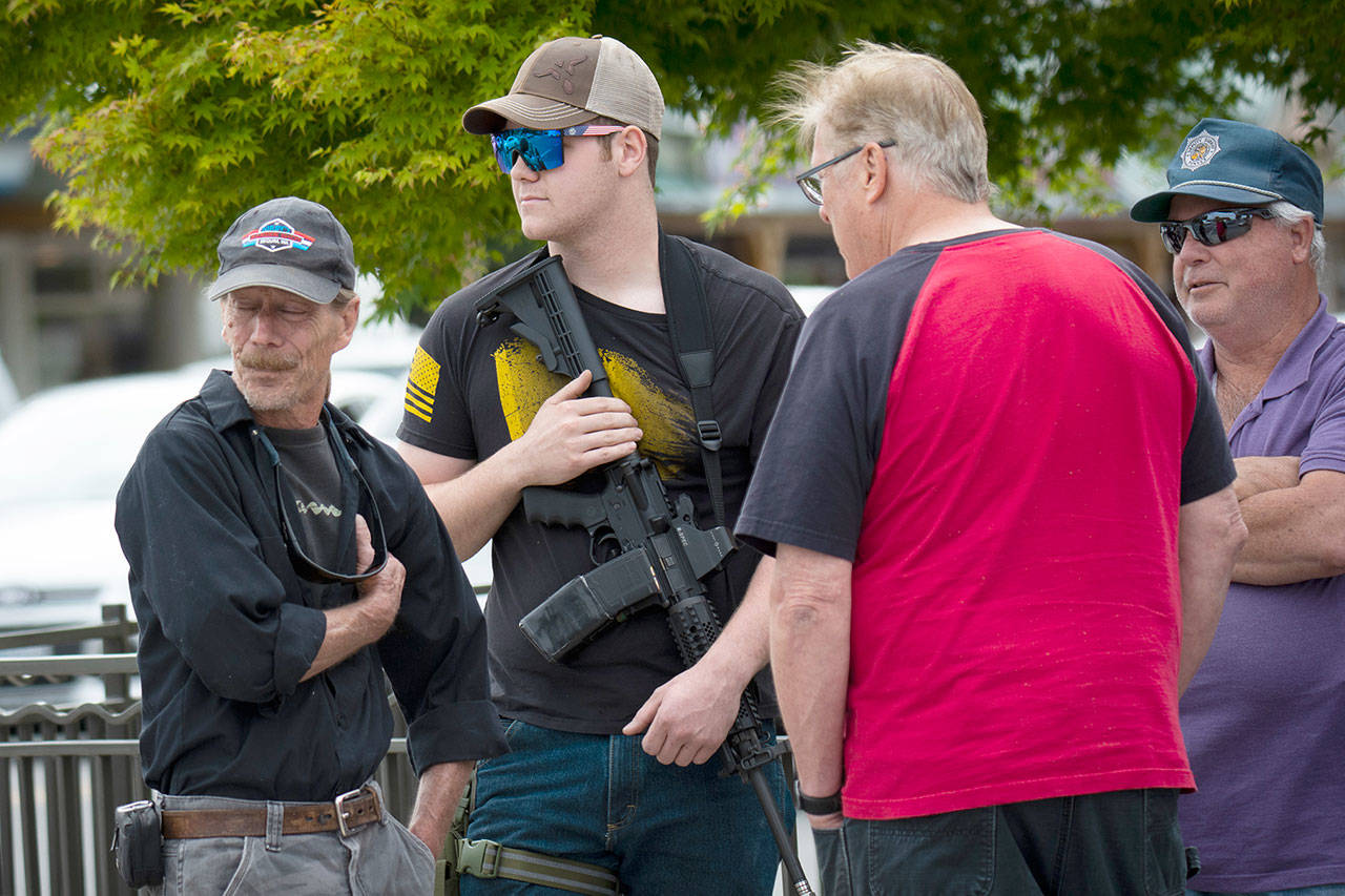 A few men with guns attended the peaceful protest in Sequim on Wednesday. (Jesse Major/For Peninsula Daily News)                                A few men with guns attended the peaceful protest in Sequim on Wednesday. A protester open carries an AR-15 in downtown Sequim on Wednesday, following a false report that violent protesters had just arrived to Sequim. (Jesse Major/for Peninsula Daily News)