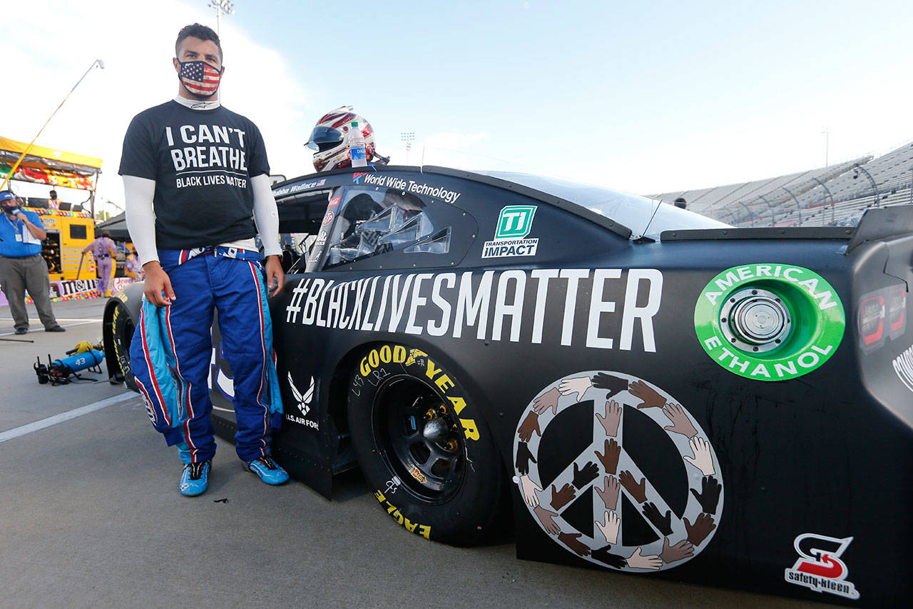 In this June 10, 2020, file photo, driver Bubba Wallace waits for the start of a NASCAR Cup Series auto race in Martinsville, Va. Bubba Wallace now counts Spike Lee and Demi Lovato – his admitted celebrity crush – as those loudly in his corner since hes become the leader of NASCARs push for change. (Steve Helber/Associated Press file)