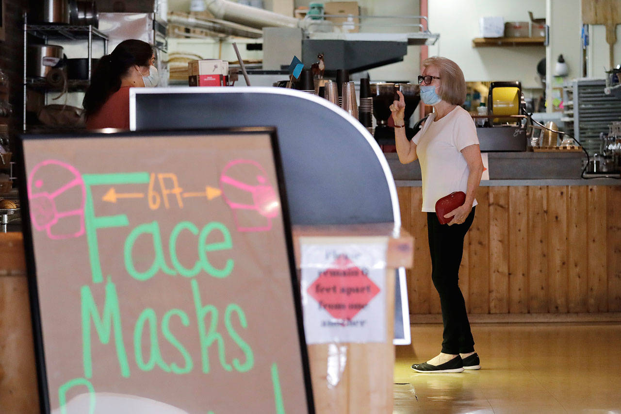 A customer, wearing a mask because of the coronavirus outbreak, puts in an order at a bakery Wednesday, June 17, 2020, in Yakima, Wash. Yakima, Benton and Franklin counties remain in Phase 1, meaning only essential businesses are open; restaurant service is limited to takeout and delivery; and limited outdoor recreation. (AP Photo/Elaine Thompson)