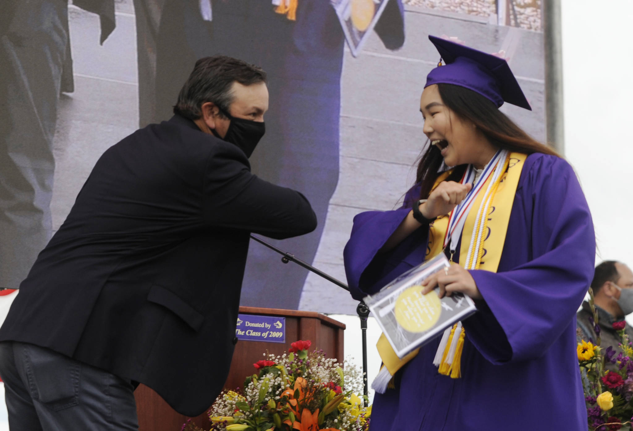 Michael Dashiell /Olympic Peninsula News Group                                After receiving her diploma, class president Erin Dwyer gets an elbow bump from Sequim High School principal Shawn Langston at Friday’s SHS commencement ceremony. Sequim Gazette photo by Michael Dashiell