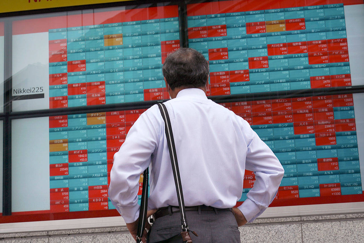 A man looks at an electronic stock board showing Japans Nikkei 225 index at a securities firm in Tokyo on Wednesday, June 24, 2020. Asian shares were mostly higher on Wednesday with another mood boost from Wall Street, but fears persist over the surge in coronavirus cases in parts of the world. (AP Photo/Eugene Hoshiko)