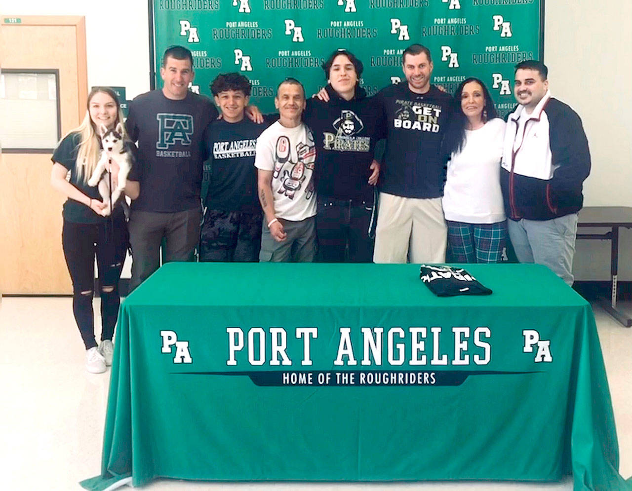 Port Angeles Roughrider Gary Johnson III signed last week to play basketball for Peninsula College. At his signing, from left are Cedar Johnson, Port Angeles head coach Kasey Ulin, Kason Albaugh, Gary Johnson Jr, Gary Johnson III, Peninsula College head coach Donald Rollman, Gayla Johnson and Eddie Perez.