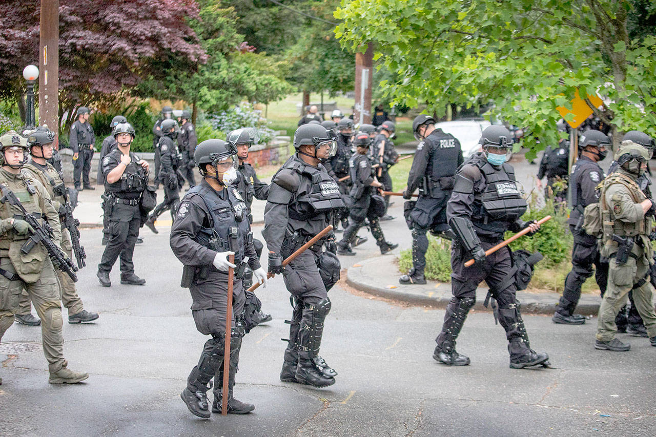 Seattle Police finish their sweep Wednesday on the north end of Cal Anderson Park, sweeping everyone off the grounds. (Steve Ringman/The Seattle Times via The Associated Press)