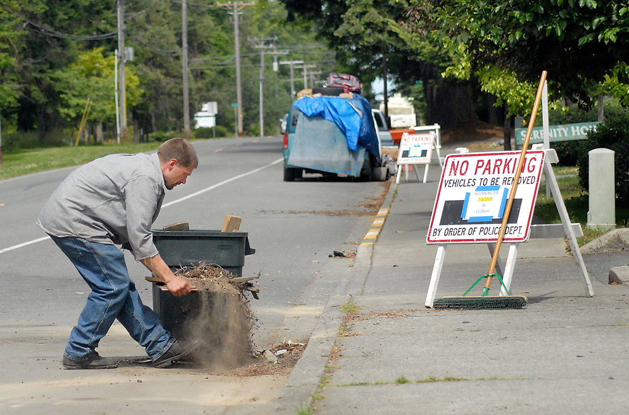 Guy Lesure picks up dirt and debris left behind by people living in cars in campers along West 18th Street near Serenity House in Port Angeles on Wednesday, July 1, 2020. Car campers were ordered to remove their vehicles by 11 a.m. Wednesday and most had pulled up stakes and moved on by the appointed time. (Keith Thorpe/Peninsula Daily News)
