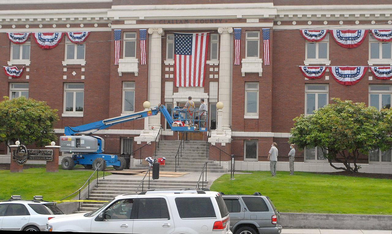 Clallam County Courthouse workers hang bunting on the front of the historic Port Angeles courthouse Wednesday, July 1, 2020, in honor of Independence Day. (Keith Thorpe/Peninsula Daily News)