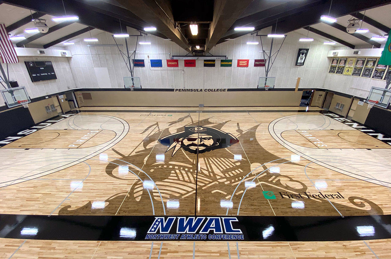 A new basketball floor, funded entirely by community donations, has been installed at Peninsula College. The new home court, featuring Pirate Pete and a new pirate ship silhouette, replaces the college’s original hardwood floor after 53 years of service. (Rick Ross/Peninsula College Athletics)