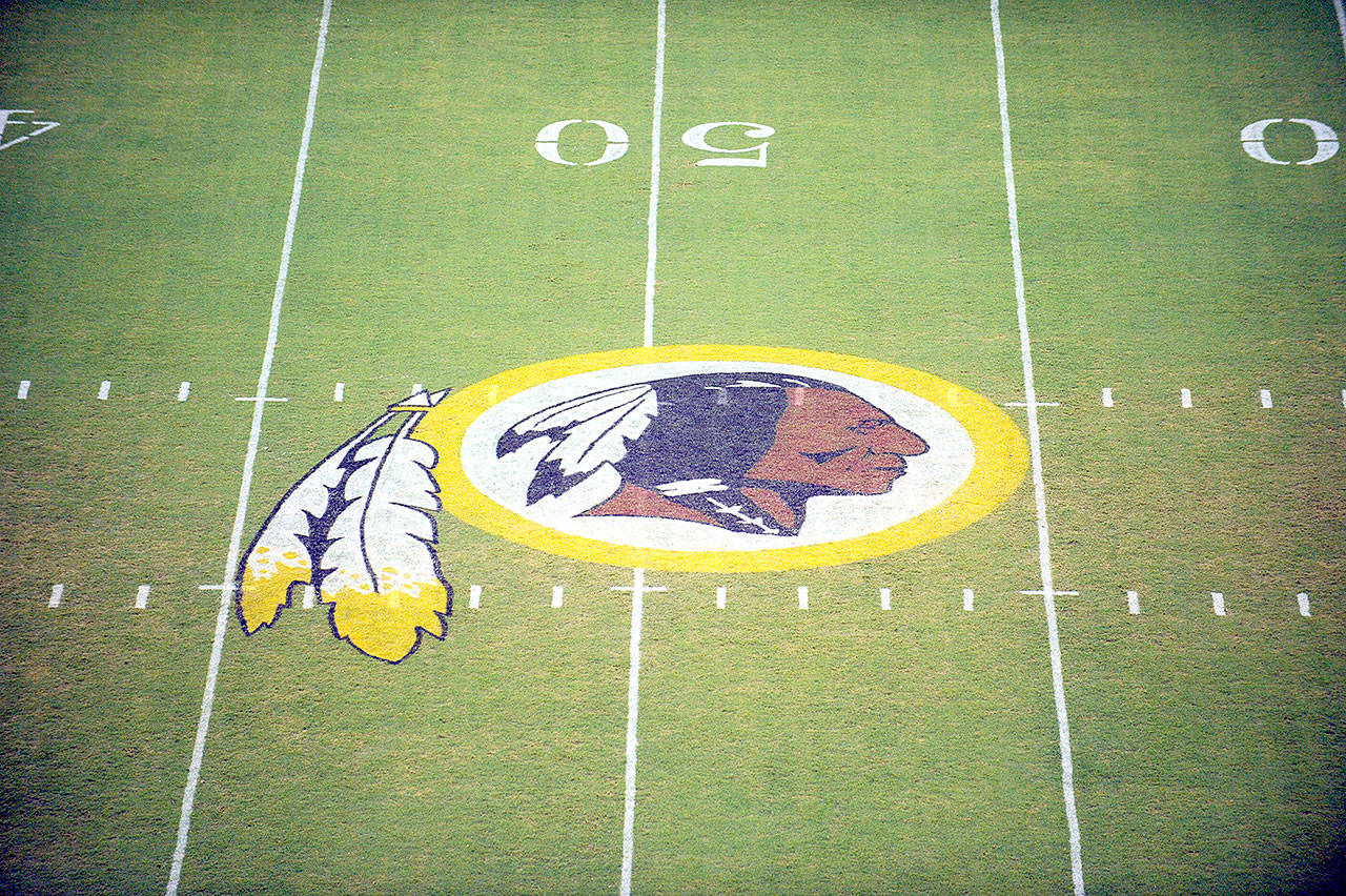 In this Aug. 28, 2009, file photo, the Washington Redskins logo is shown on the field before the start of a preseason NFL football game against the New England Patriots in Landover, Md. The Washington NFL franchise announced Monday that it will drop the “Redskins” name and Indian head logo immediately, bowing to decades of criticism that they are offensive to Native Americans. (Nick Wass/Associated Press file)