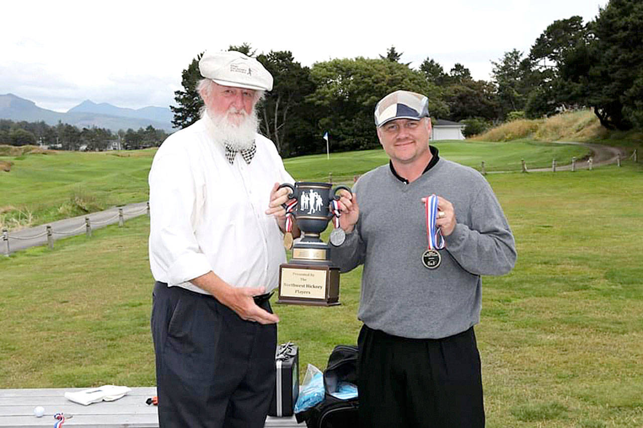 Gabe Tonan from Port Townsend, right, receives his trophy for winning the Gearhart Hickory Classic in Gearhart, Ore., on July 11.