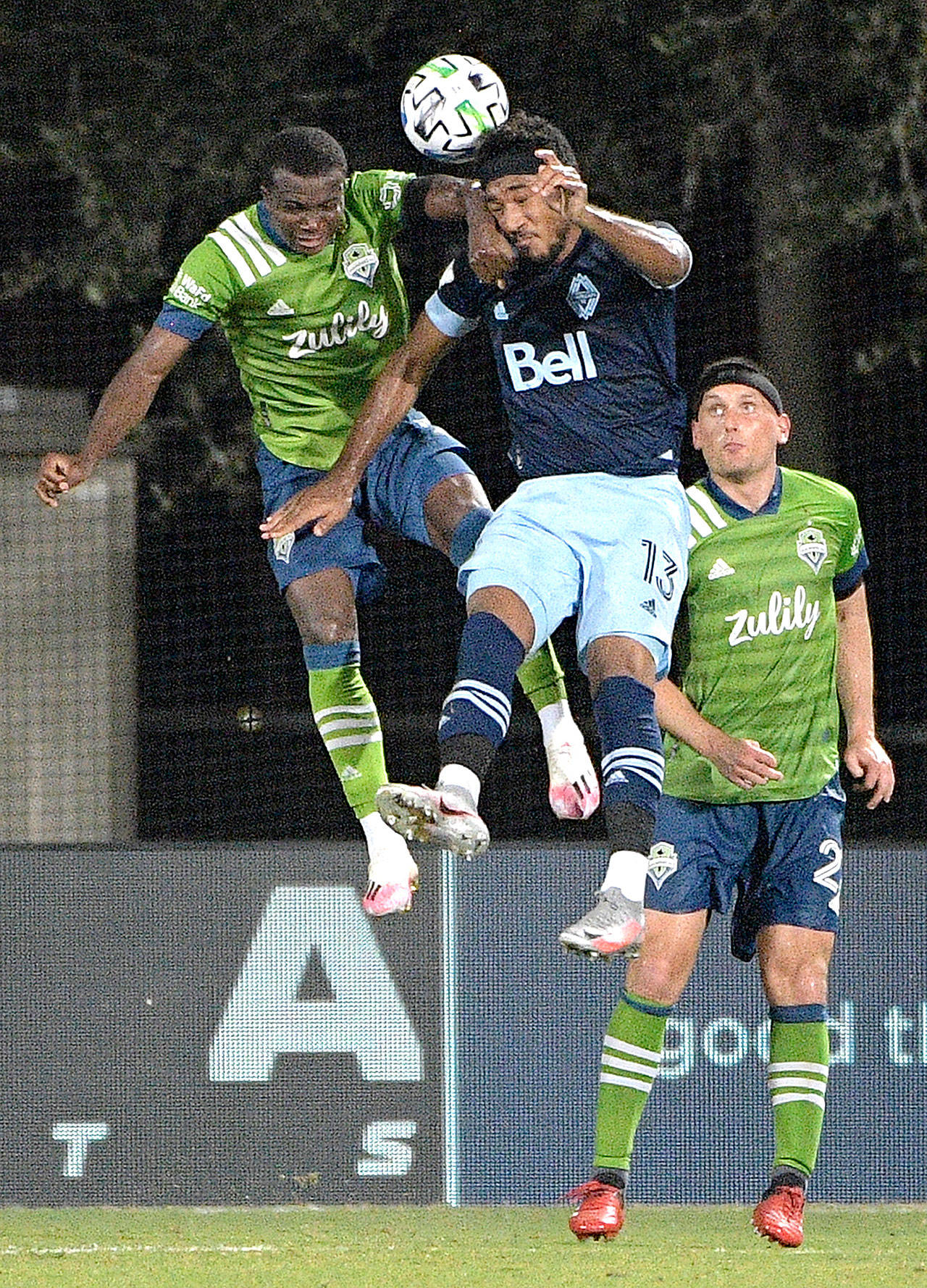 Seattle Sounders defender Shane O’Neill, right, watches as defender Nouhou Tolo, left, and Vancouver Whitecaps defender Derek Cornelius (13) compete for a header during the second half of an MLS soccer match, Monday, July 20, 2020, in Kissimmee, Fla. (Phelan M. Ebenhack/Associated Press)