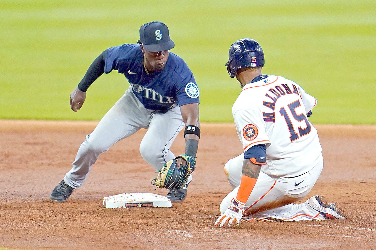 Houston Astros’ Martin Maldonado (15) is tagged out by Seattle Mariners second baseman Shed Long Jr. while trying to stretch a single into a double during the third inning of a baseball game Saturday, July 25, 2020, in Houston. (AP Photo/David J. Phillip)