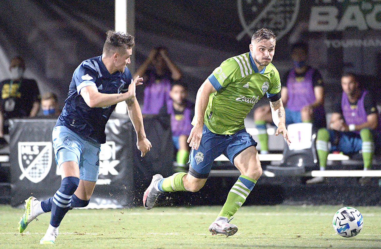 Seattle Sounders forward Jordan Morris, right, controls the ball in front of Vancouver Whitecaps defender Jake Nerwinski during the second half of an MLS soccer match, Sunday, July 19, 2020, in Kissimmee, Fla. (AP Photo/Phelan M. Ebenhack)