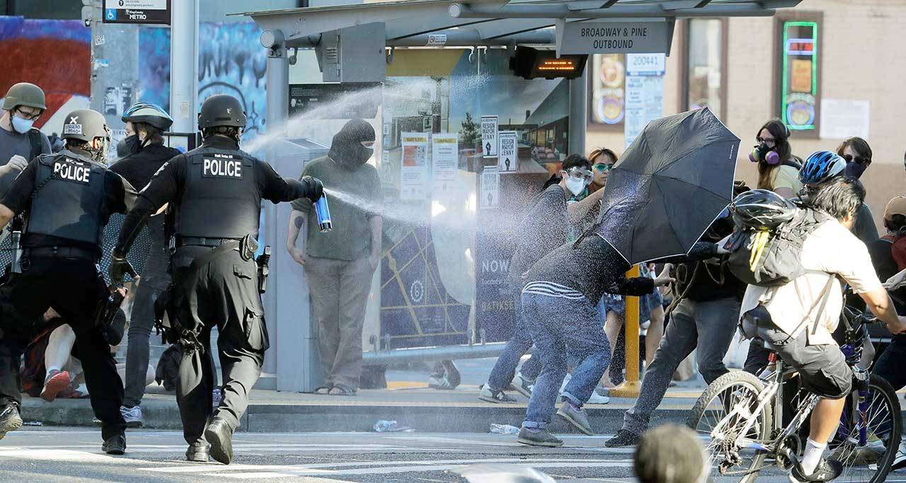 Police pepper spray protesters Saturday near Seattle Central Community College. A large group of protesters were marching in support of Black Lives Matter and against police brutality and racial injustice. (Ted S. Warren/The Associated Press)