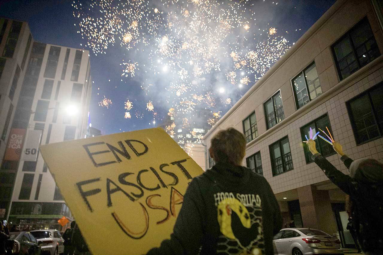 Protesters light fireworks in the middle of downtown Oakland, Calif., during a protest on Saturday. Protesters in California set fire to a courthouse, damaged a police station and assaulted officers after a peaceful demonstration intensified late Saturday, police said. (Christian Monterrosa/The Associated Press)