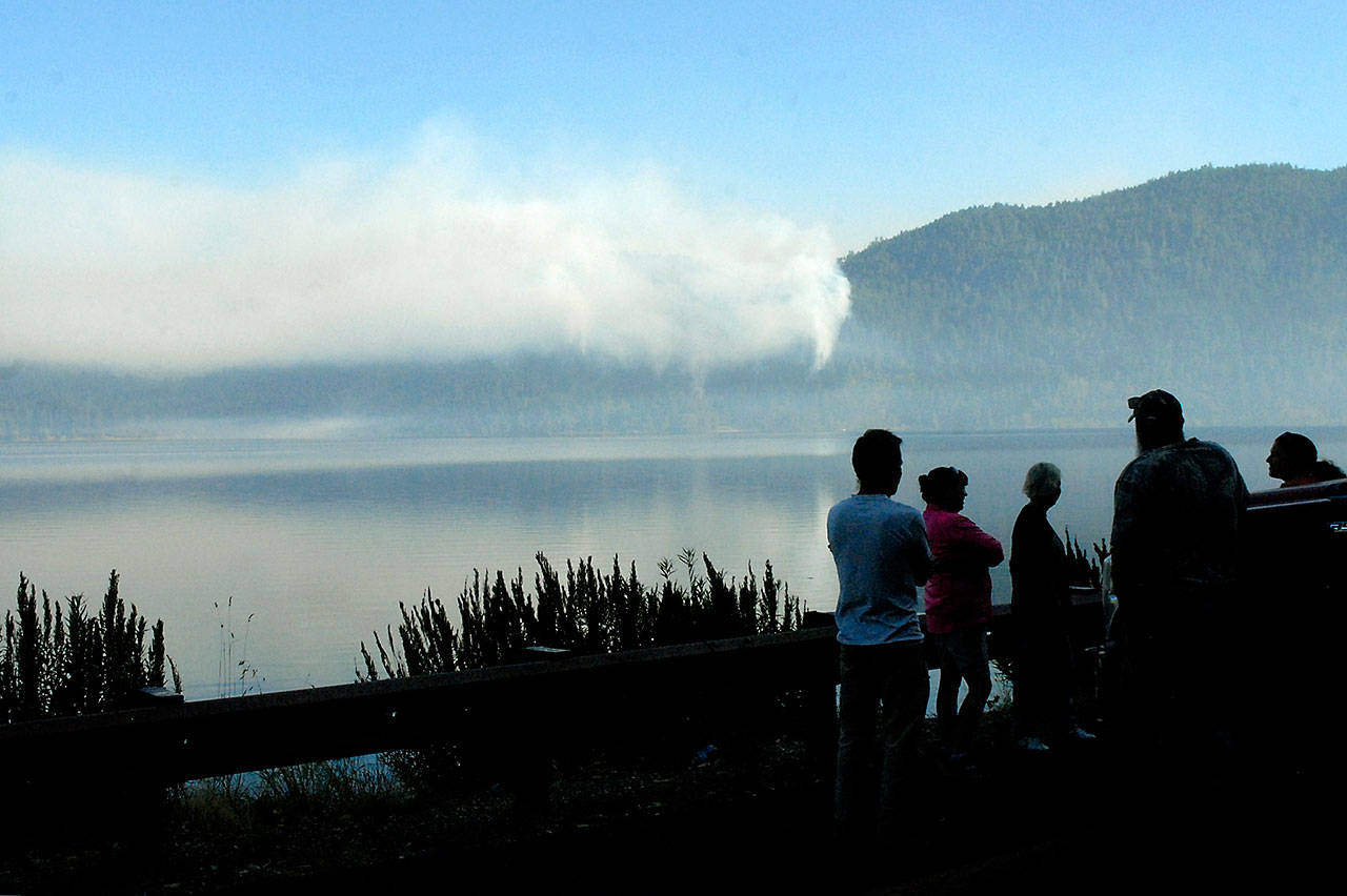 Bystanders watch a wildland fire above East Beach Road from a turnout along U.S. Highway 101 at Lake Crescent on Thursday morning. (Keith Thorpe/Peninsula Daily News)