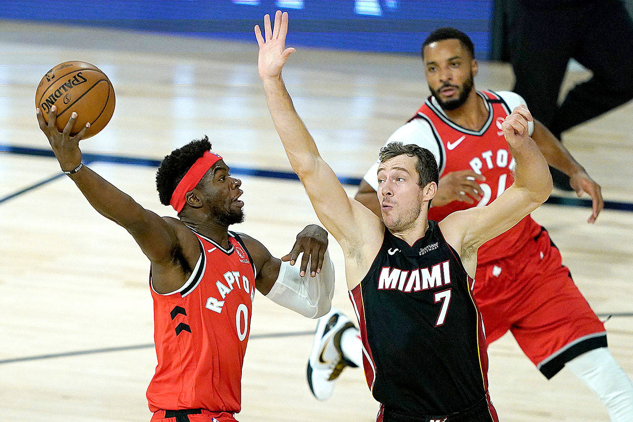 Toronto Raptors’ Terence Davis (0) shoots over Miami Heat’s Goran Dragic (7) during the first half of an NBA basketball game Monday, Aug. 3, 2020, in Lake Buena Vista, Fla. (AP Photo/Ashley Landis, Pool)