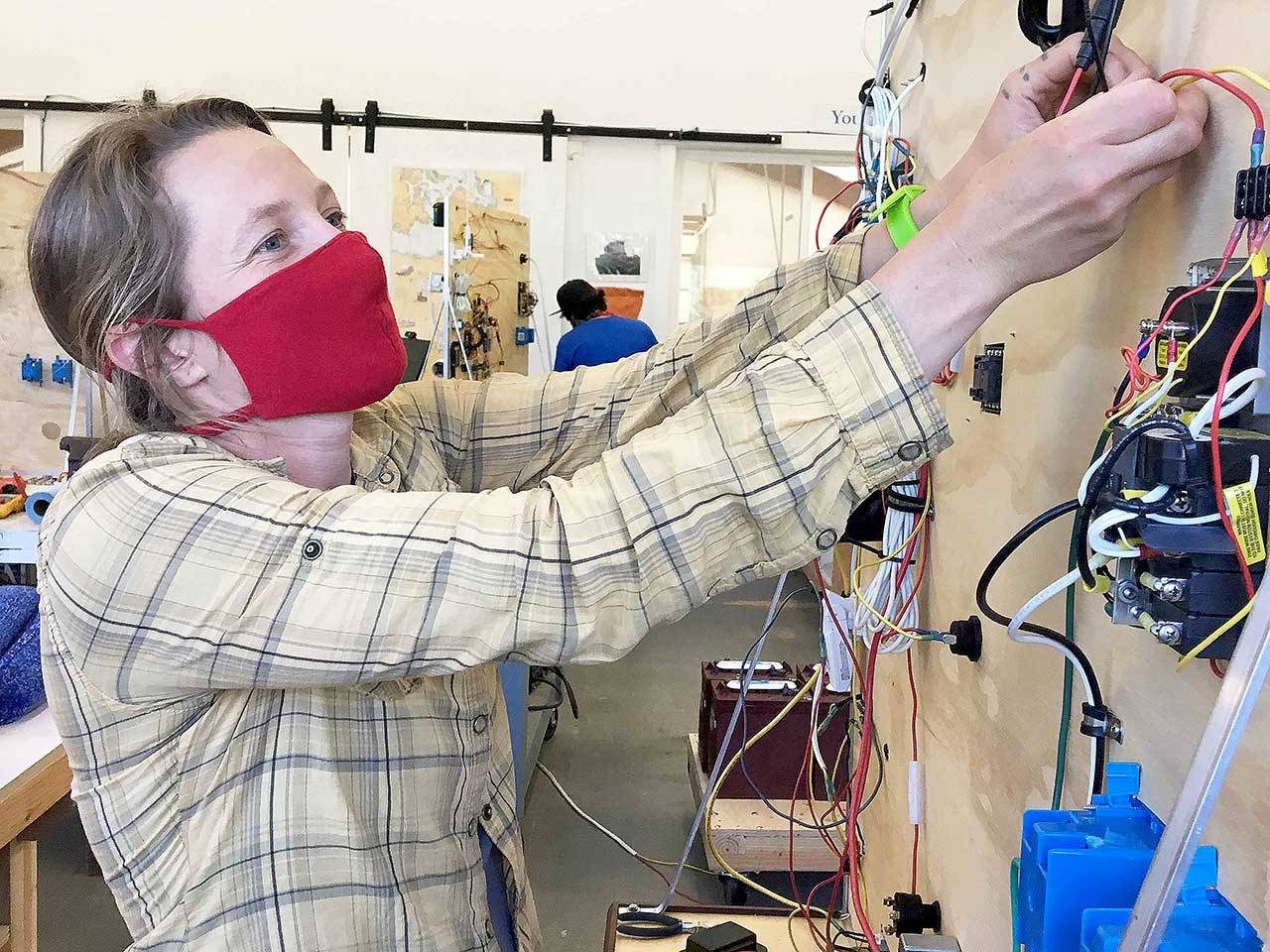 Marine Systems student Anna Casey Witte practices wiring her electrical board. She plans to use her new skills on her families’ fishing operation in Bristol Bay, as well as crabbing in Puget Sound. (Photo courtesy of Northwest School of Wooden Boatbuilding)