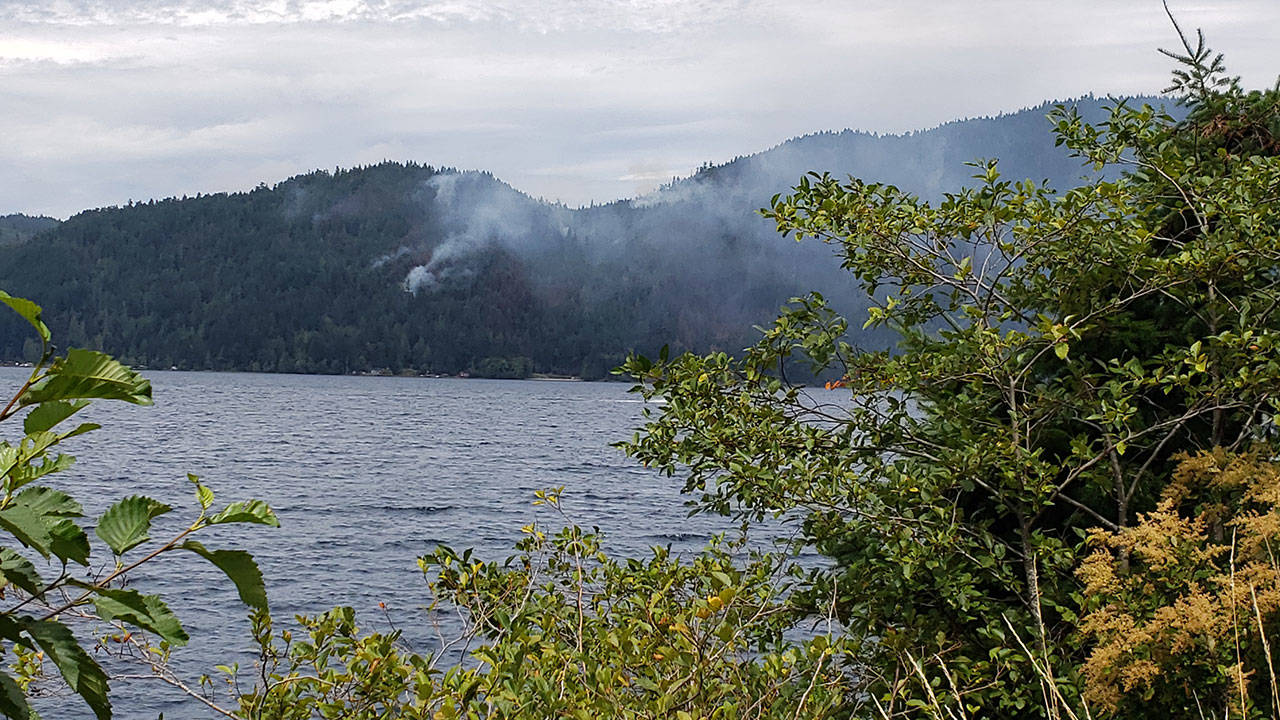 The East Beach Road Fire burns above Lake Crescent in Olympic National Park on Sunday, Aug. 2, 2020, as seen from a U.S. Highway 101 pull-off area. (Laura Foster/Peninsula Daily News)