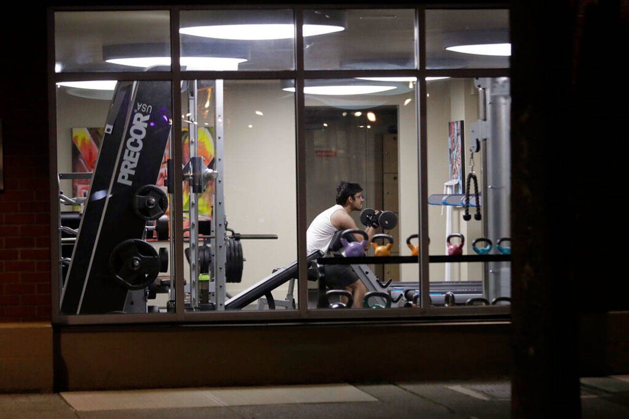 A man works out in a gym at an apartment building in downtown Seattle on Sunday, March 15, 2020. (Ted S. Warren/Associated Press file)